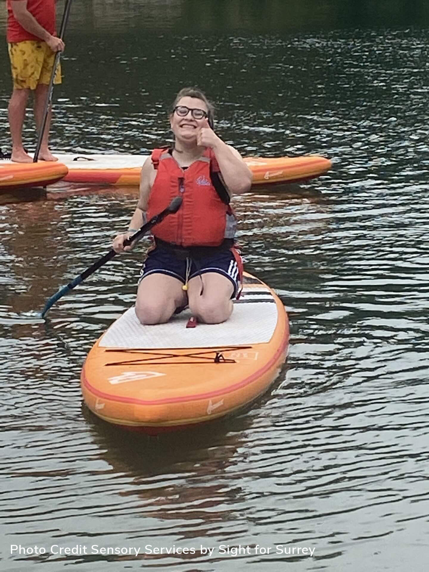 young woman giving the thumbs up on canoe in the river